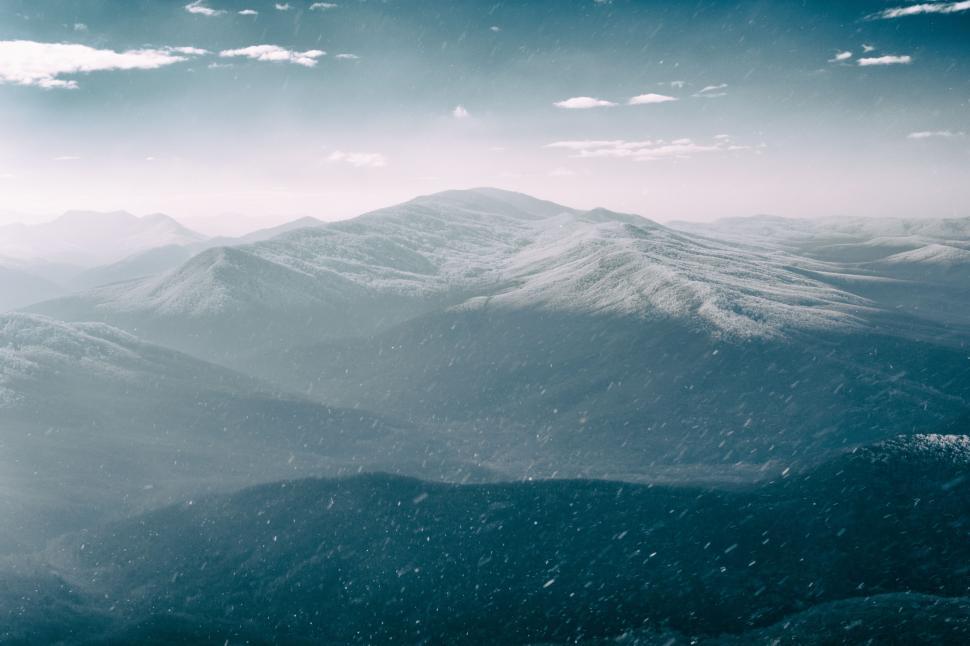 Free Image of Snow-Covered Mountain Range Under Cloudy Sky 