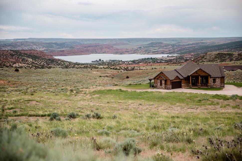 Free Image of House Amid Field With Lake Background 