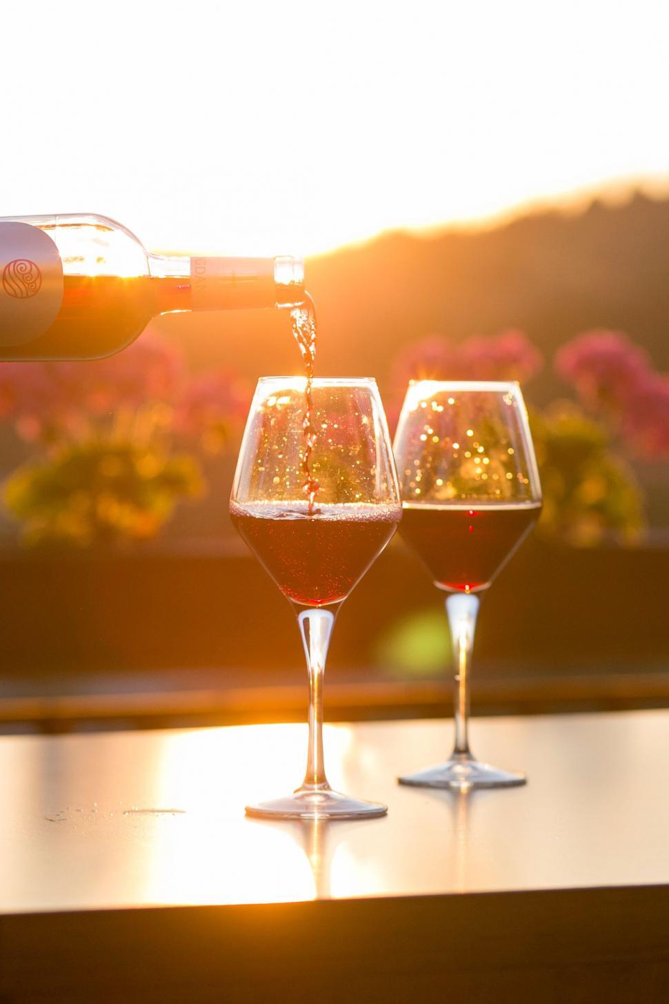 Free Image of Person Pouring Wine Into Two Wine Glasses 