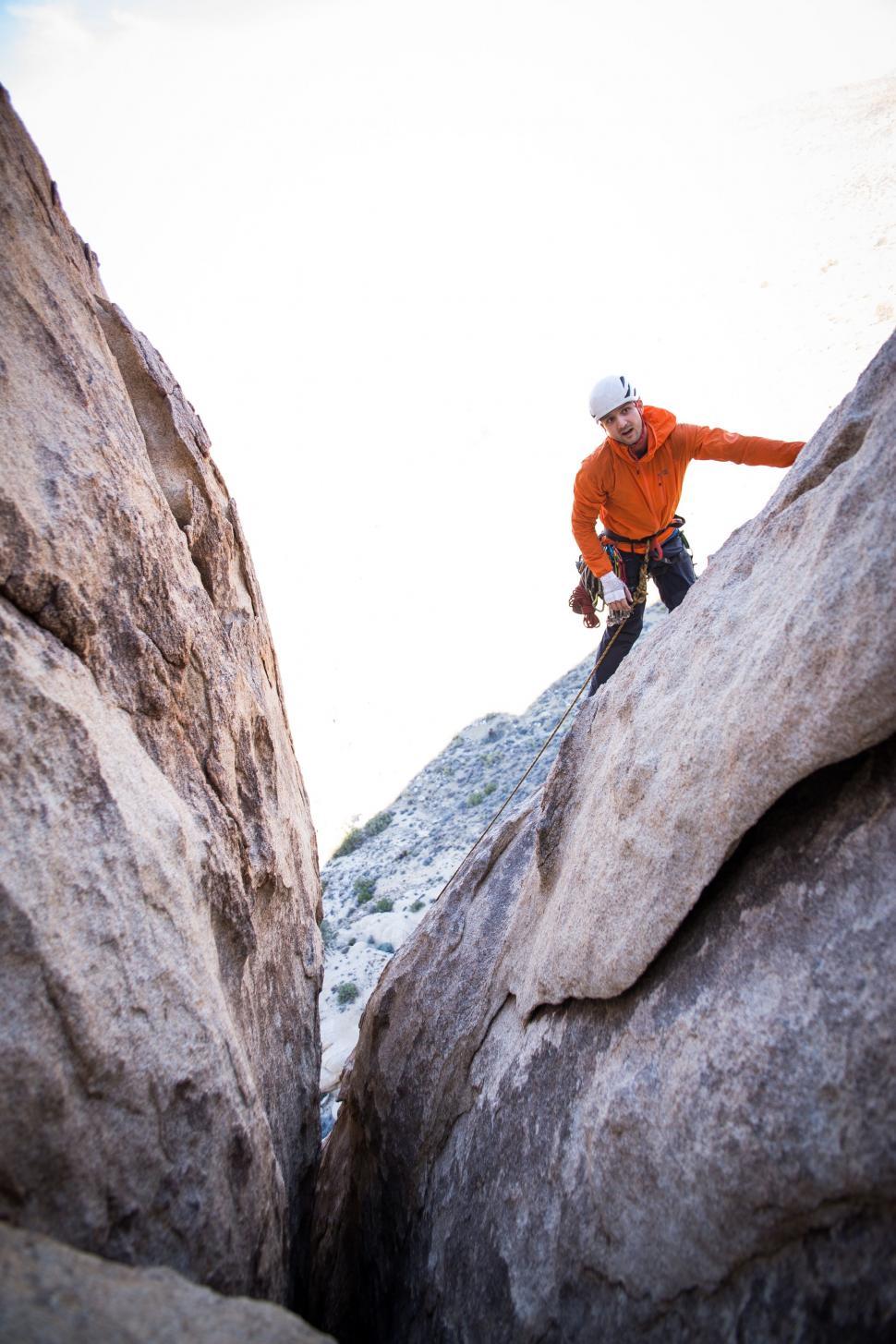 Free Image of Man Climbing Up the Side of a Mountain 