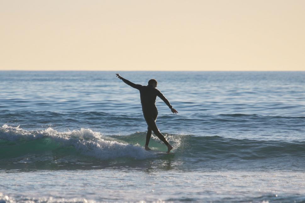 Free Image of Man Riding Wave on Surfboard 
