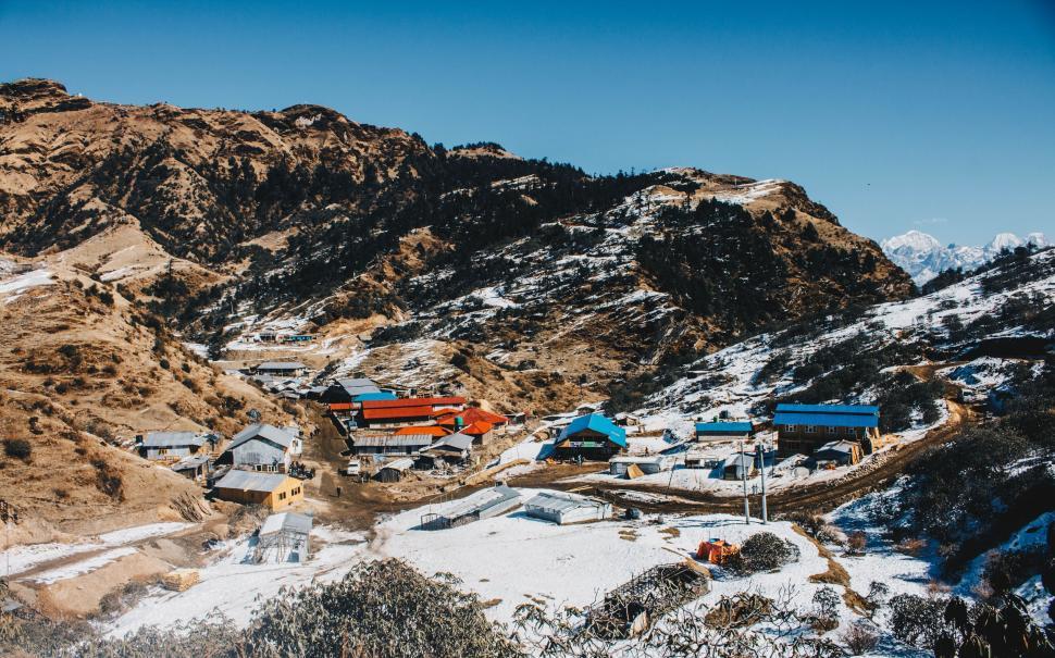 Free Image of Snow-Covered Mountain With Village in Distance 