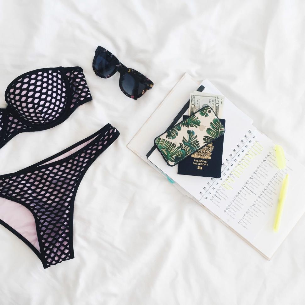 Free Image of Bikinis and Book on Bed 