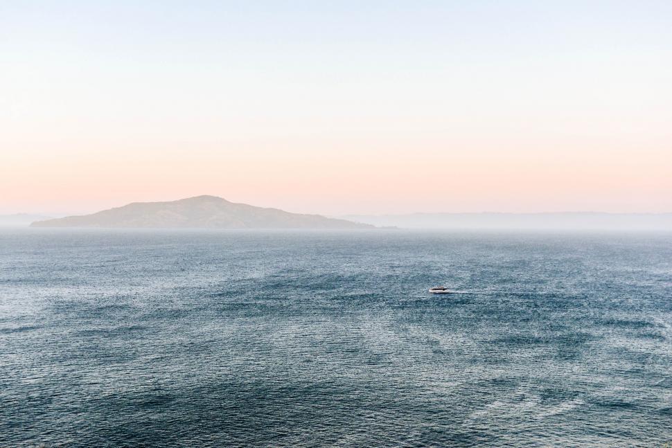 Free Image of Large Body of Water With Small Island in the Distance 