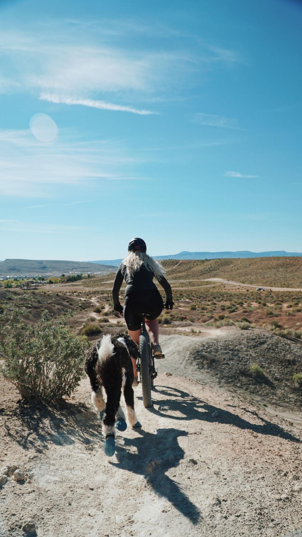 Free Image of Man Riding Bike Down Dirt Road 