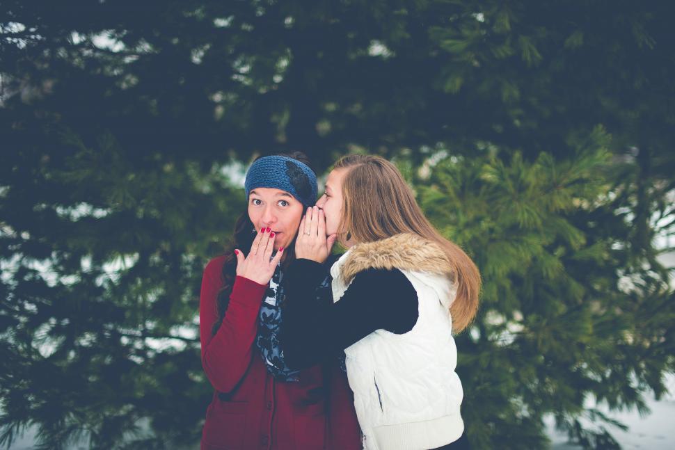 Free Image of Two Women Standing Together in the Snow 