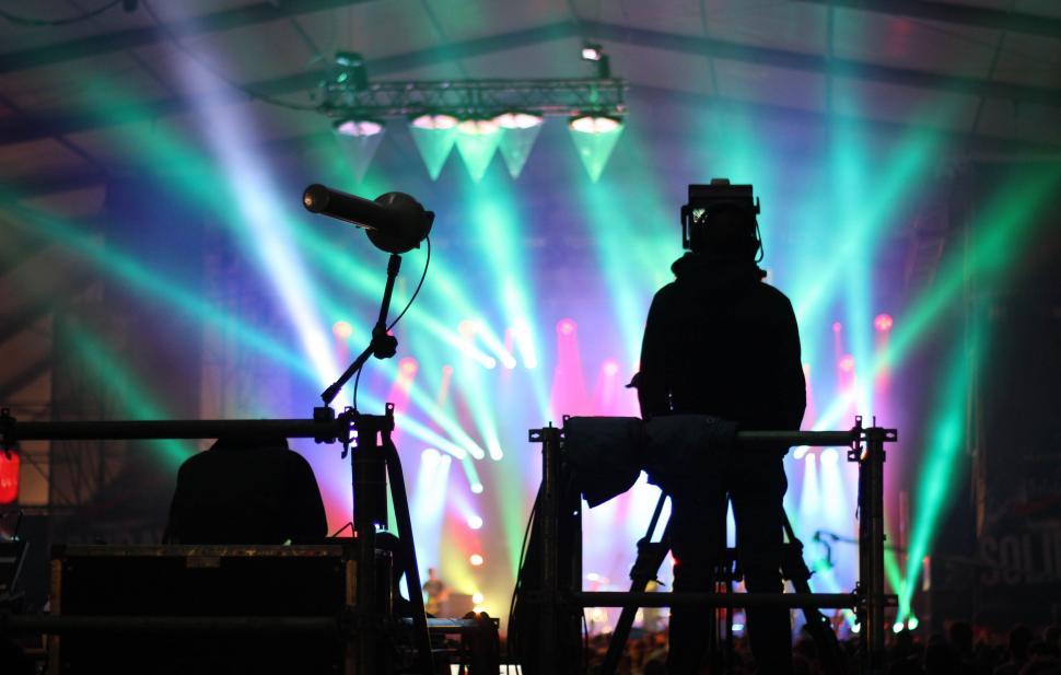 Free Image of Man Standing in Front of Microphone on Stage. 