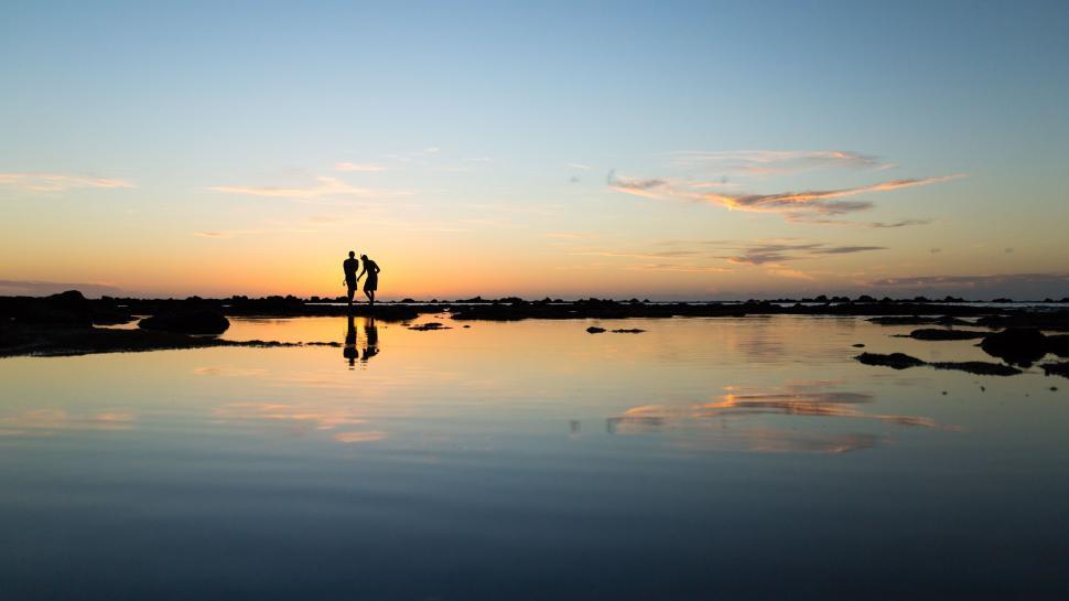 Free Image of People Standing on Top of Body of Water 
