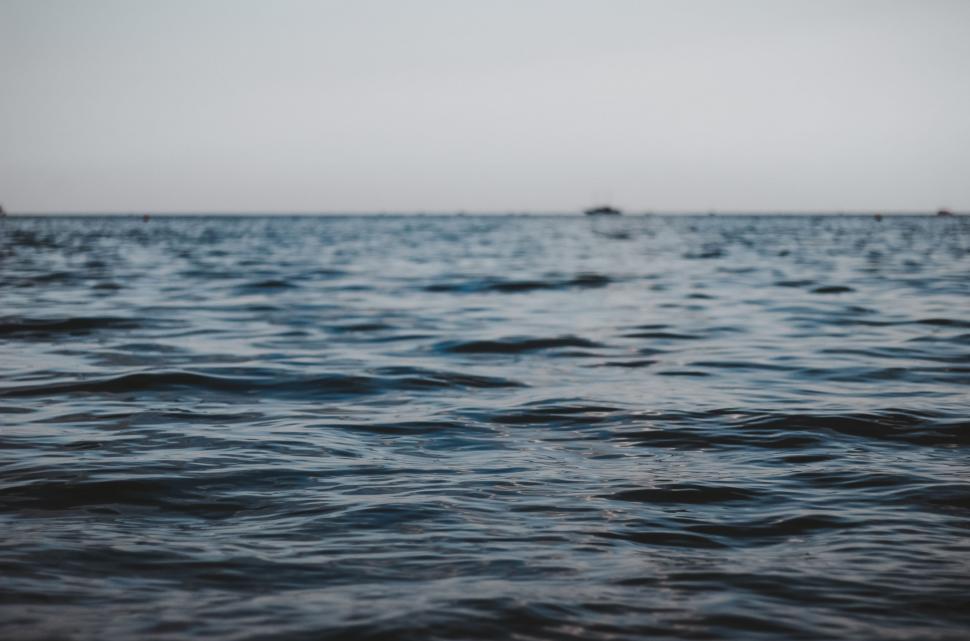Free Image of Boat Sailing on Distant Body of Water 