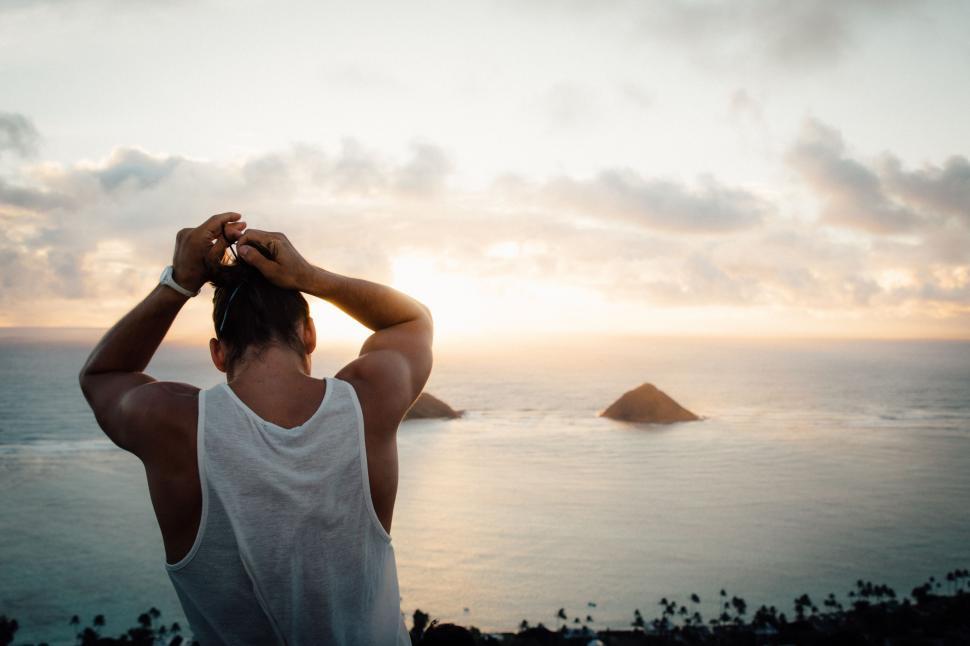 Free Image of Man Standing on Hill Next to Ocean 