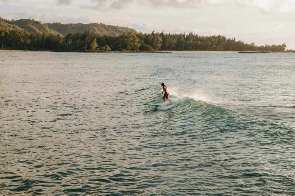 Free Image of Person Riding Surfboard on Body of Water 