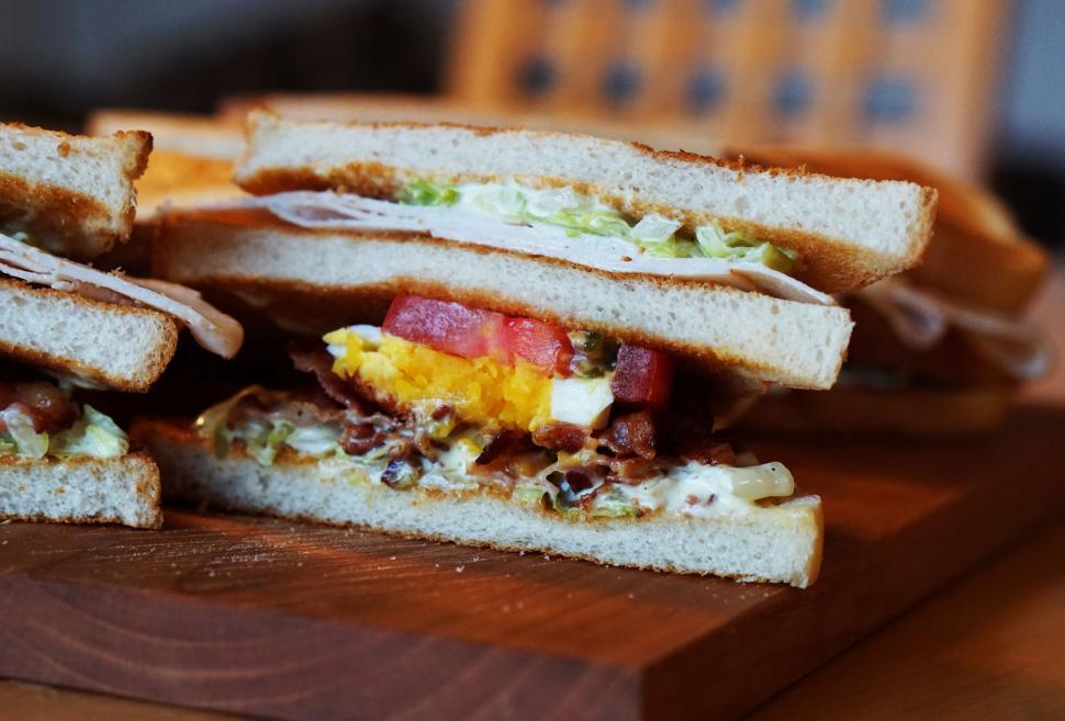 Free Image of Halved Sandwich on Wooden Cutting Board 