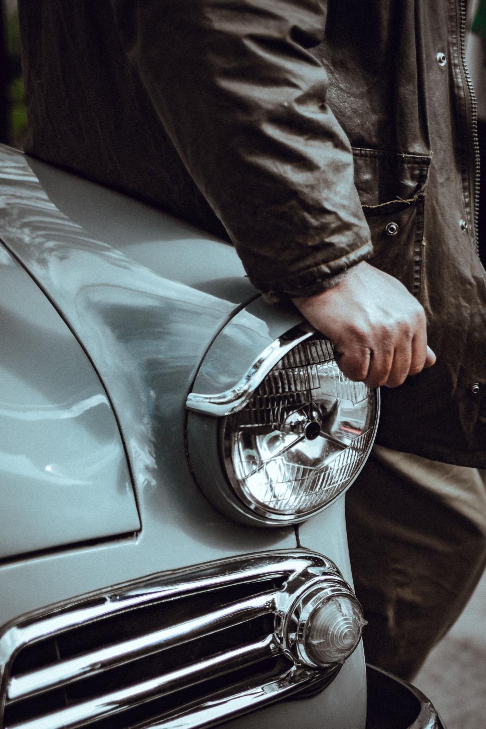 Free Image of Man Standing Next to Parked Car 