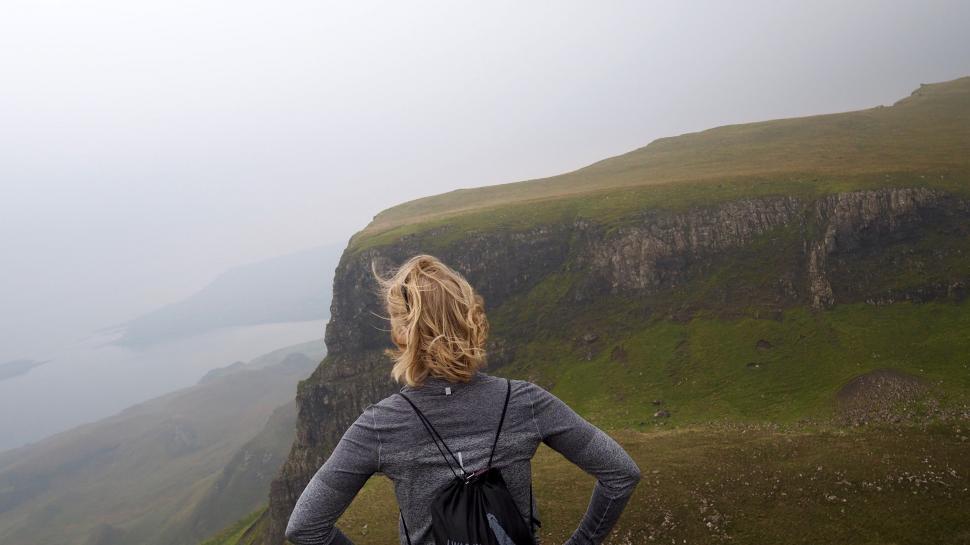 Free Image of Woman Standing on Cliff Overlooking Body of Water 