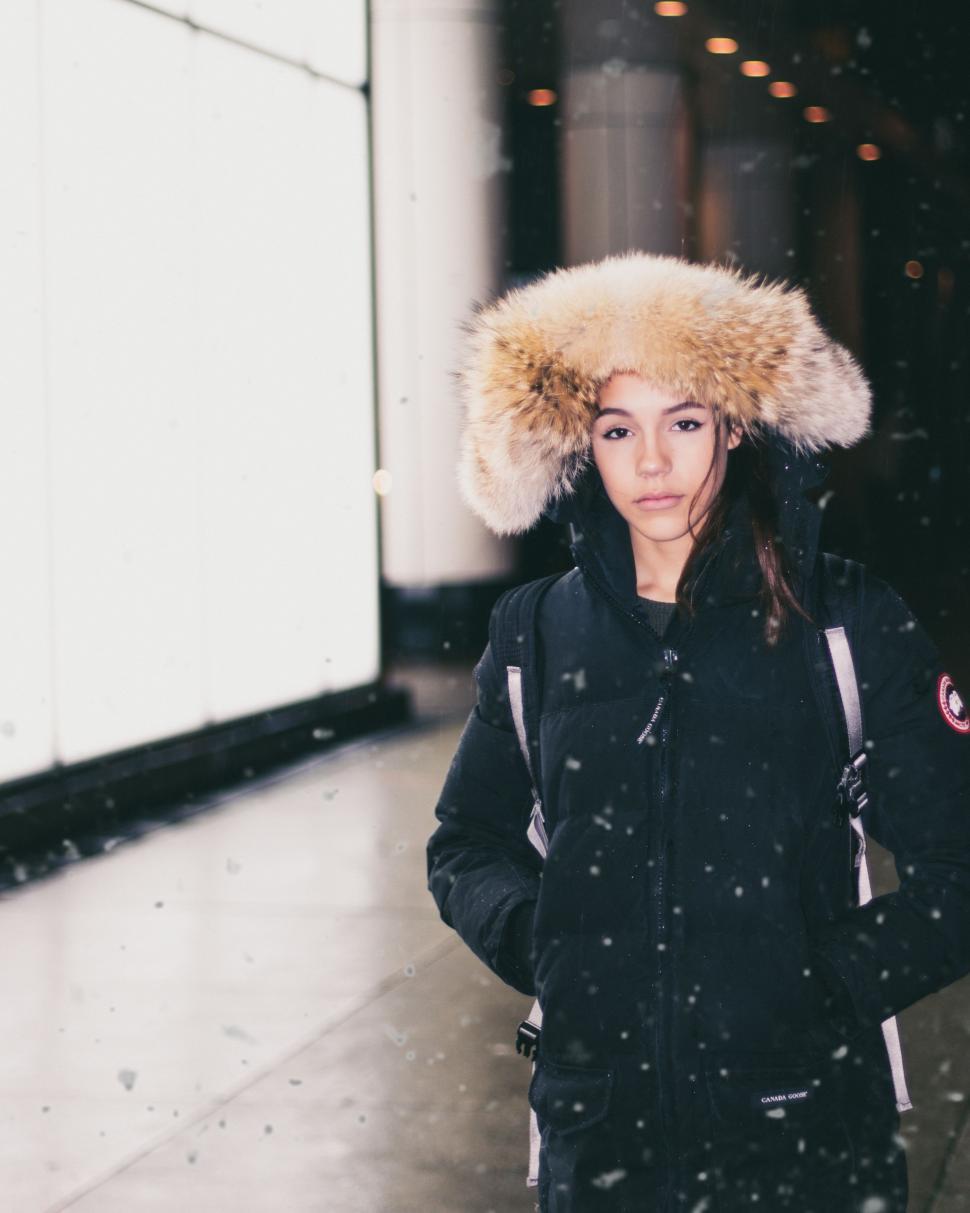 Free Image of Woman Walking Down a Street in Fur Hat 