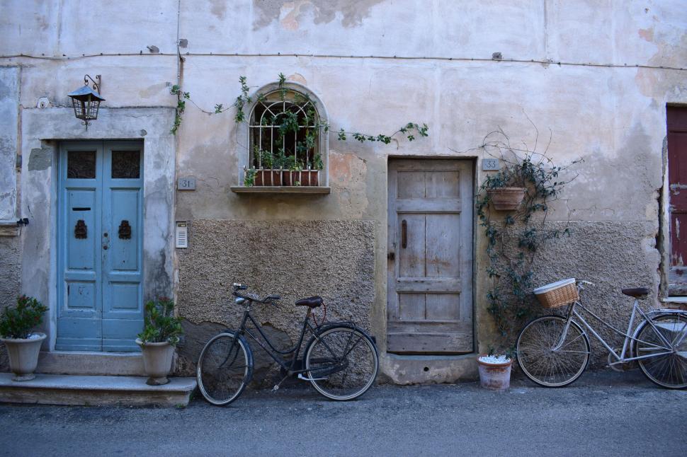 Free Image of Two Bikes Parked Next to Building 