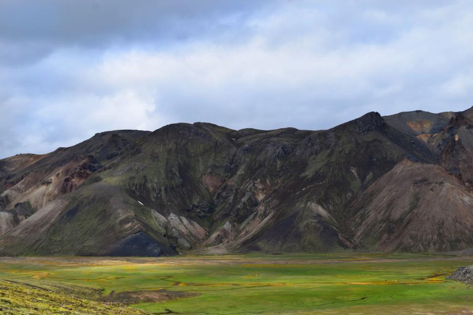 Free Image of Green Field in Front of Majestic Mountain Range 
