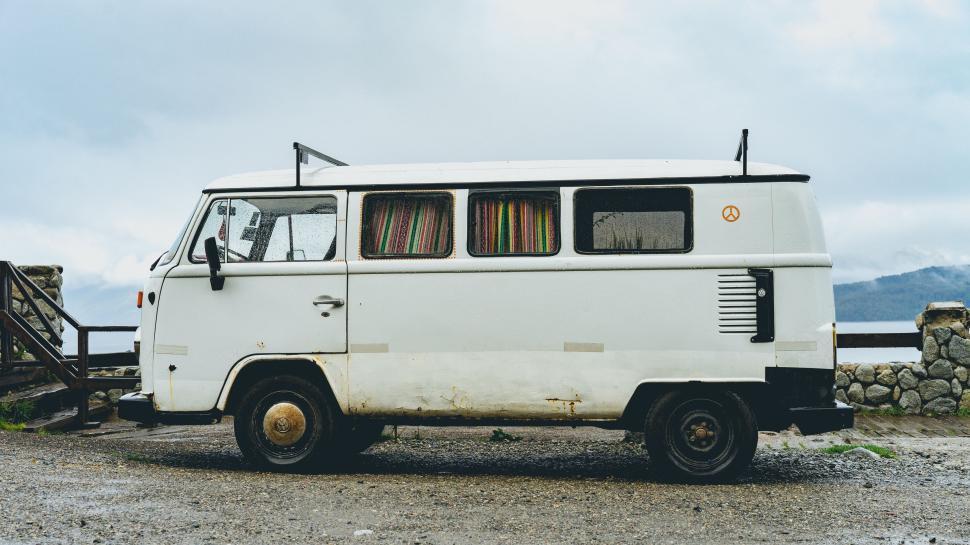 Free Image of White Van Parked Next to Stone Wall 
