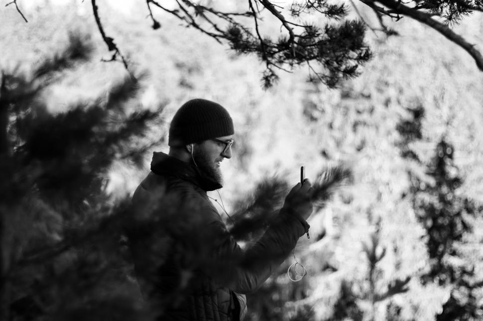 Free Image of Man Stands in Woods Holding Cigarette 