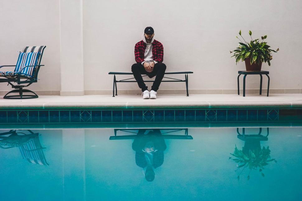 Free Image of Man Sitting on Chair by Swimming Pool 