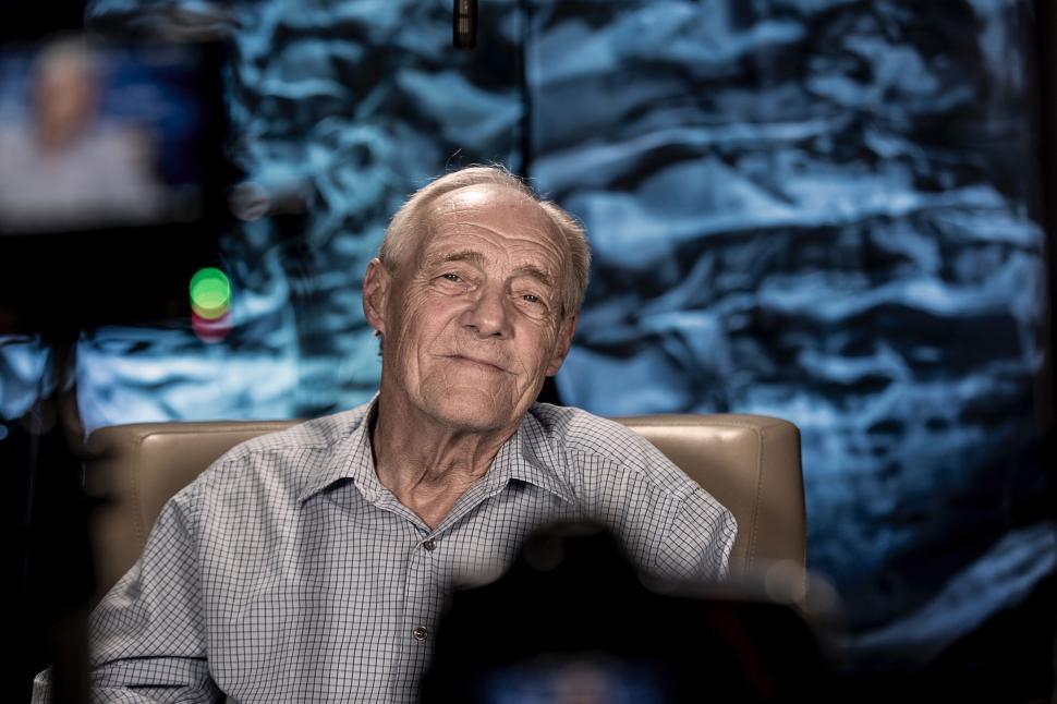 Free Image of Older Man Sitting in Chair Against Wall 