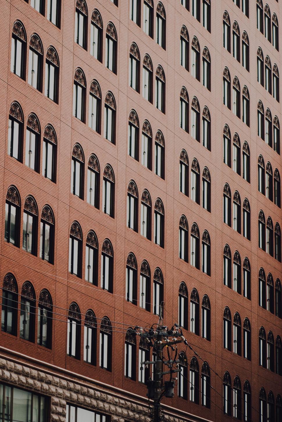 Free Image of Tall Building With Clock and Many Windows 