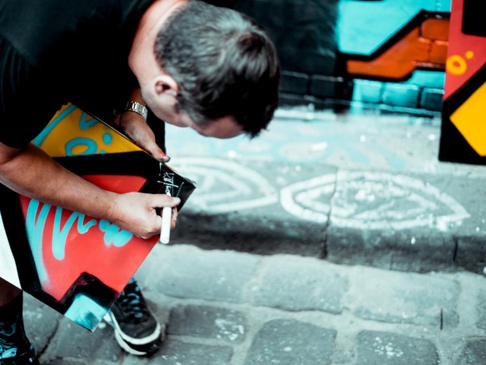 Free Image of Man Holding Skateboard on Sidewalk 