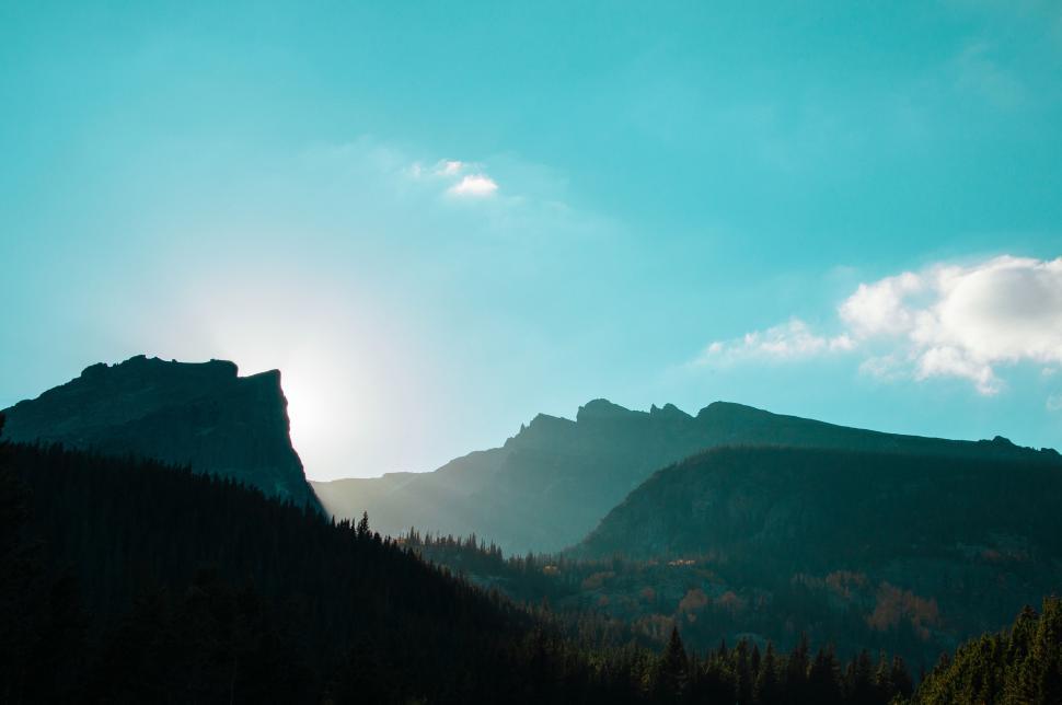 Free Image of Sunlight Streaming Through Clouds Over Mountain Range 