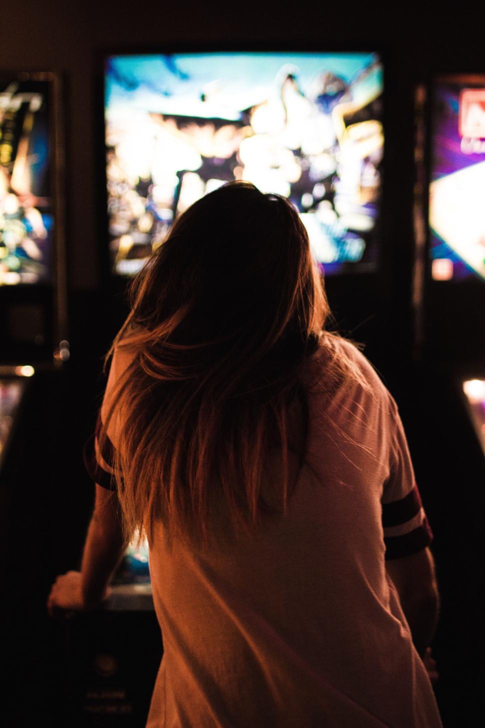Free Image of Woman Standing in Front of Row of Televisions 