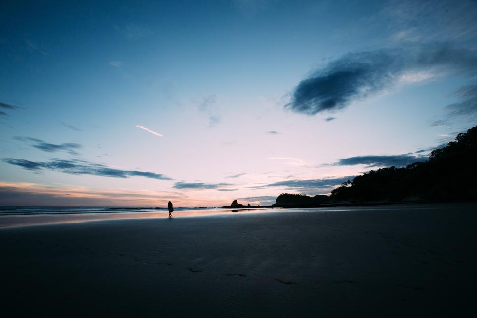 Free Image of Person Standing on Beach at Sunset 