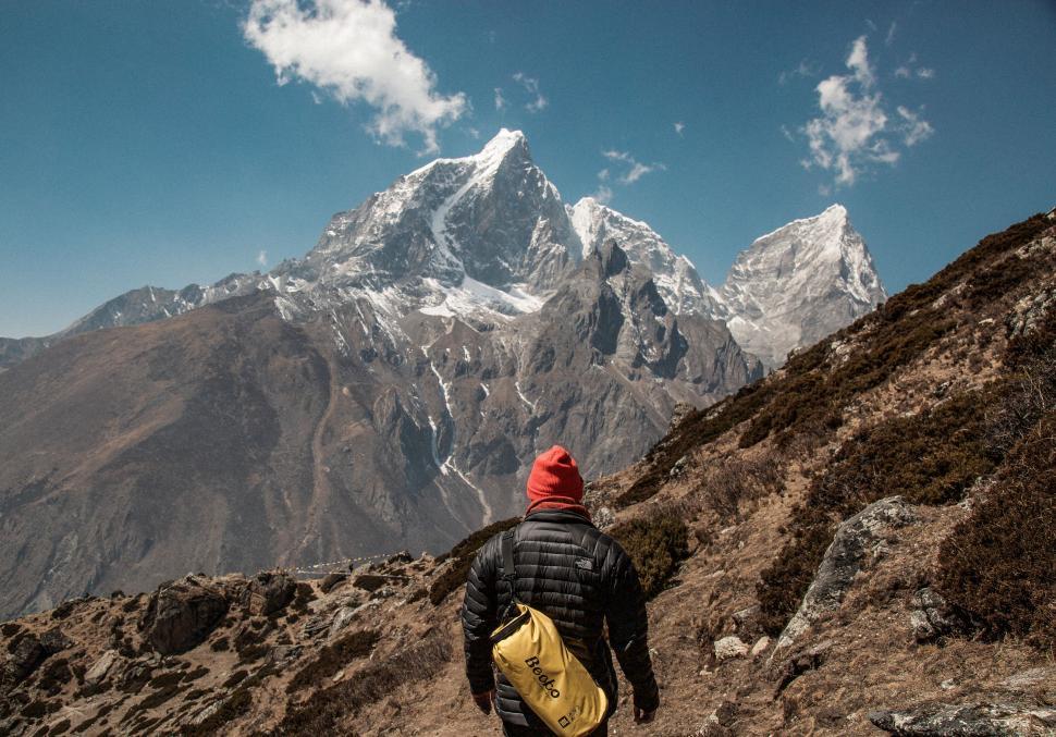 Free Image of Man With Backpack Walking Up Mountain 