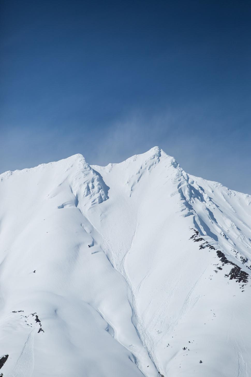 Free Image of Snowboarder Jumping off Snow Covered Mountain 