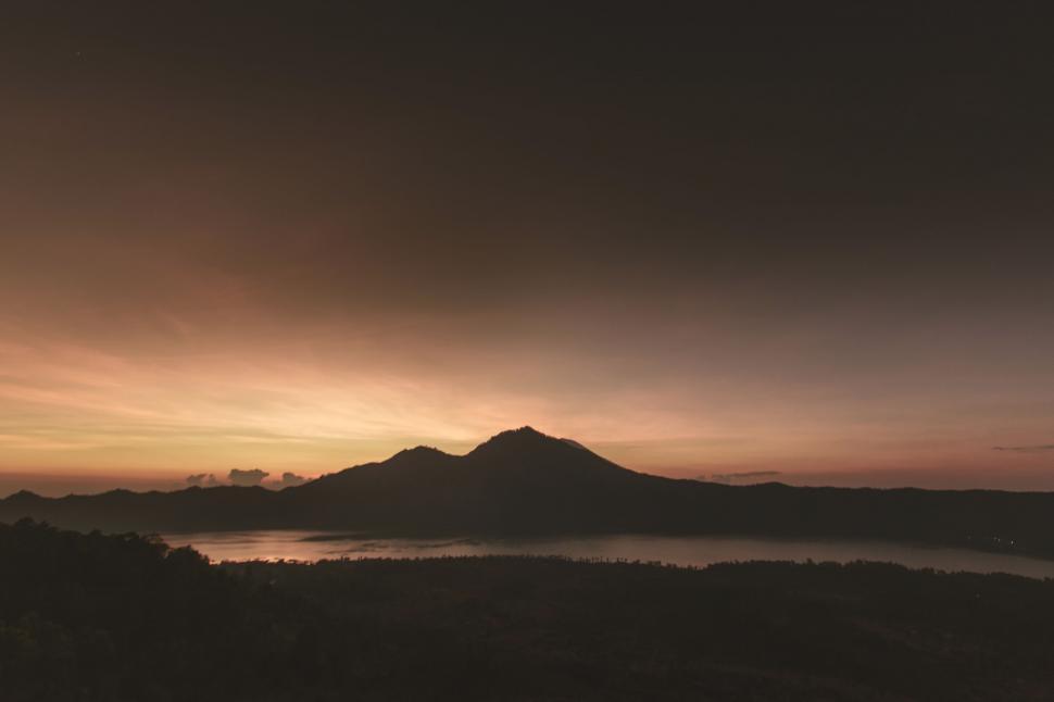 Free Image of Mountain and Body of Water Under Cloudy Sky 