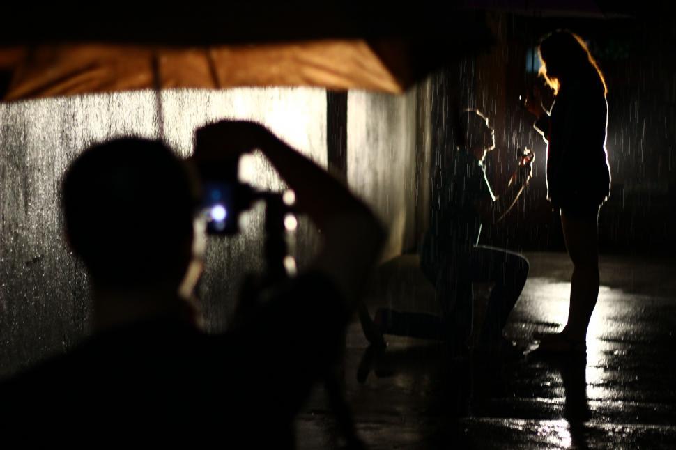 Free Image of Woman Standing in Rain Holding Umbrella 