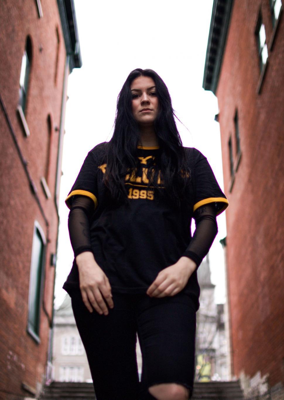 Free Image of Woman With Long Black Hair in Narrow Alleyway 