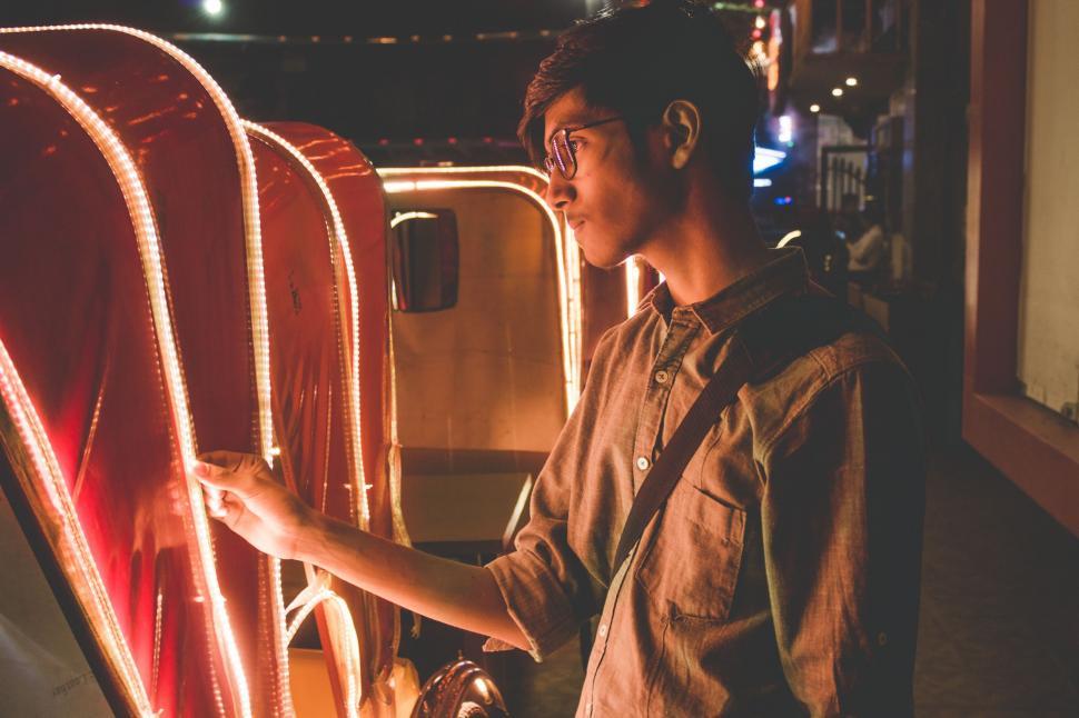 Free Image of Man Standing in Front of Display of Lights 