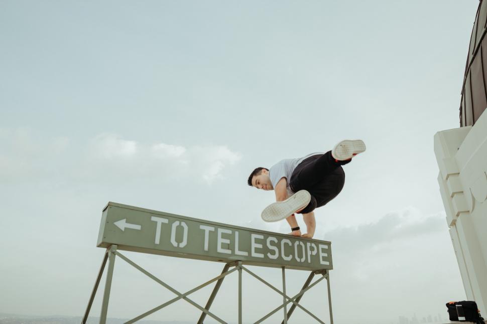 Free Image of Man Performing Trick on Sign 