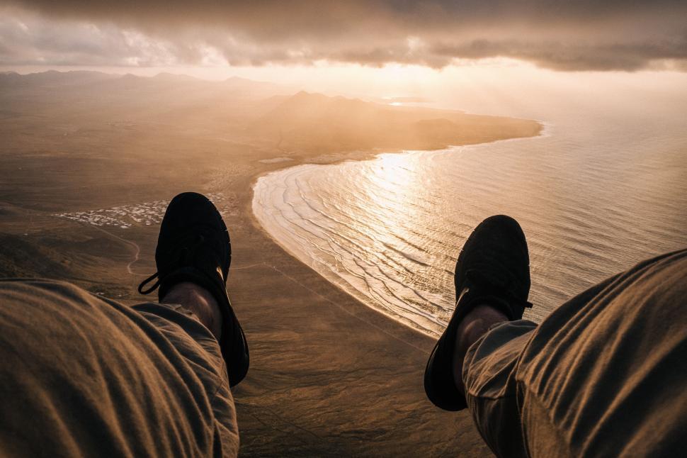Free Image of Person Standing on Beach With Feet in Air 