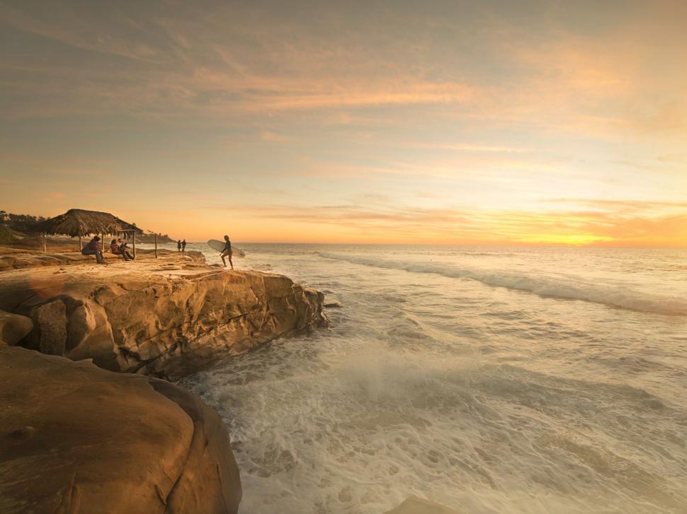 Free Image of Group of People Standing on Cliff by Ocean 