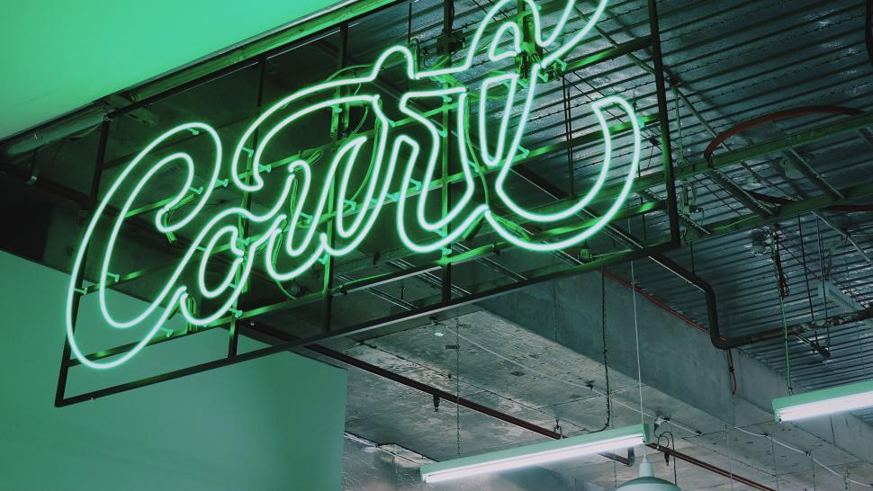 Free Image of Neon Sign Hanging From Side of Building 
