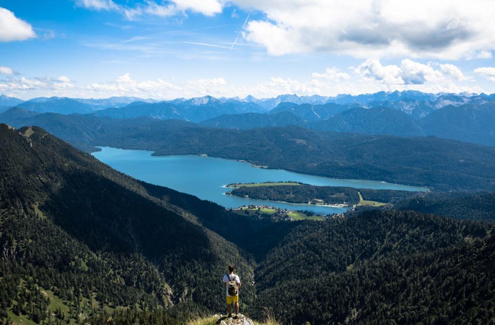 Free Image of Man Standing on Top of Lush Green Hillside 