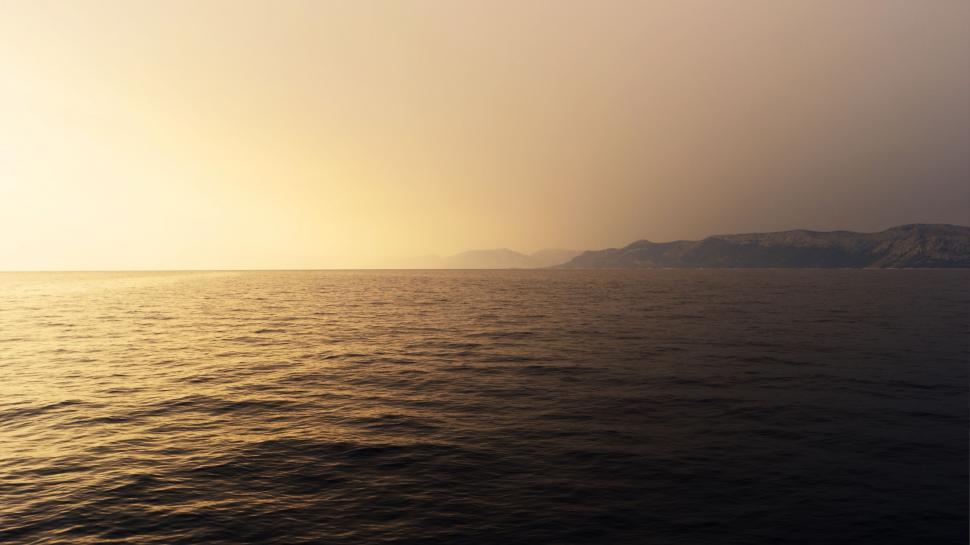 Free Image of Boat Sailing on Body of Water at Sunset 