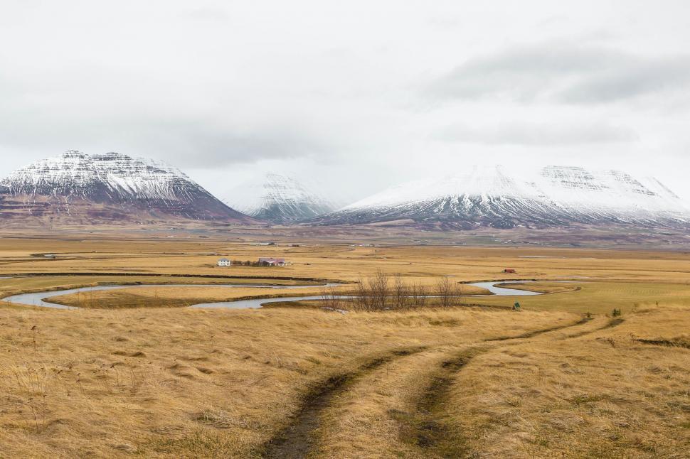 Free Image of Grassy Field With River and Mountains 