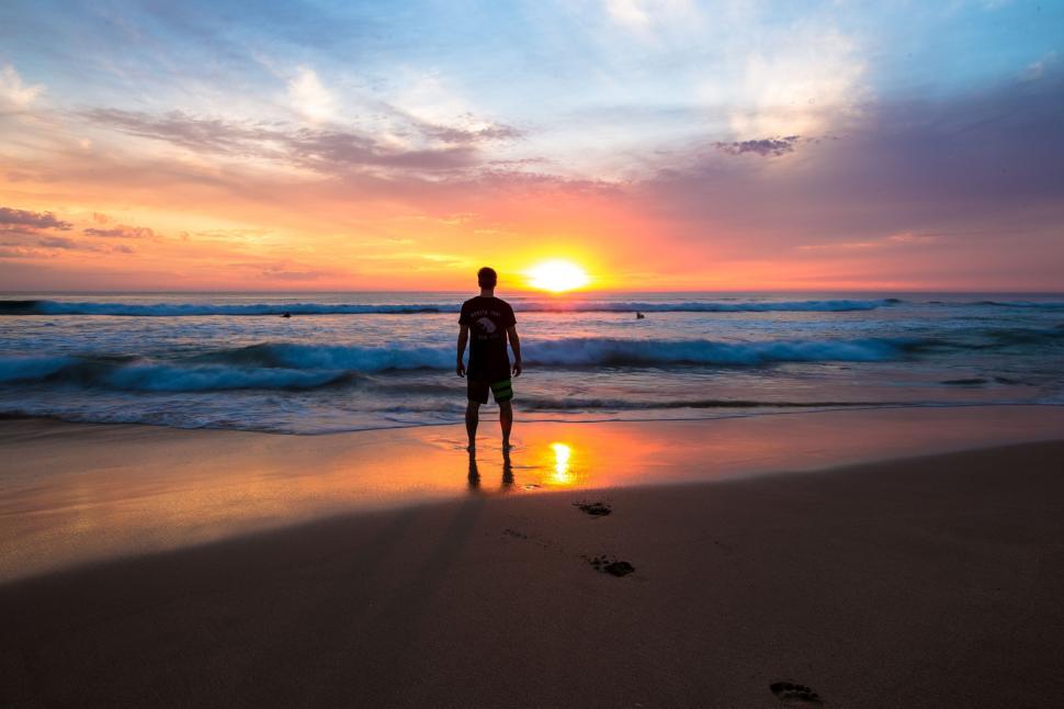 Free Image of Man Standing on Beach Next to Ocean 