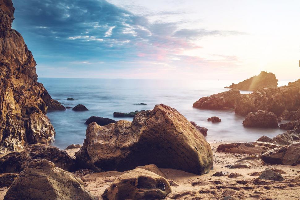 Free Image of Rocky Beach With Water in Background 