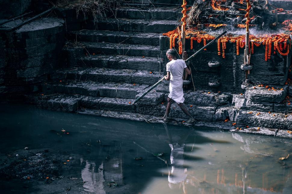 Free Image of Man Walking Up Steps With Stick 