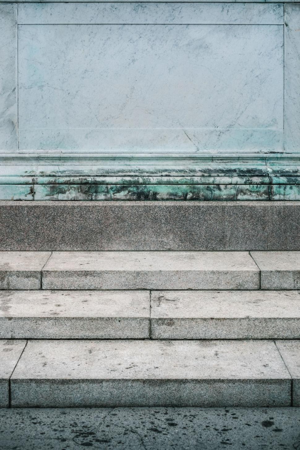 Free Image of Man Walking Down Sidewalk Next to Wall 