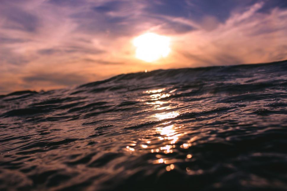 Free Image of Sun Shining Through Clouds Over Ocean 