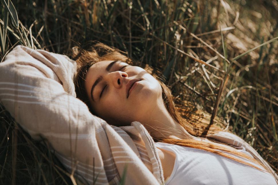 Free Image of Woman Laying in Grass With Eyes Closed 