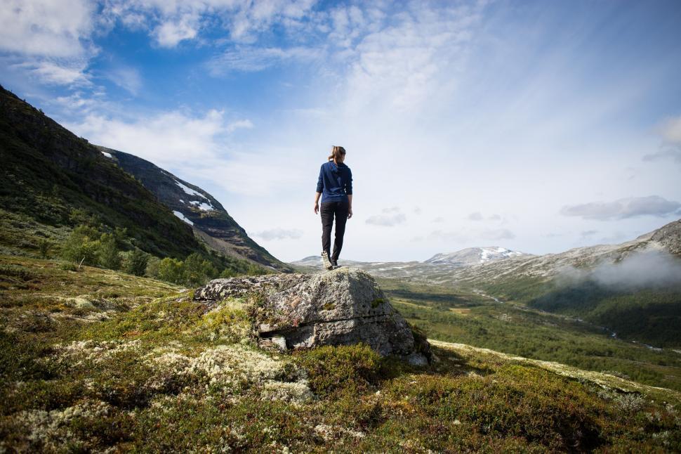 Free Image of Person Standing on Top of Rock in the Mountains 